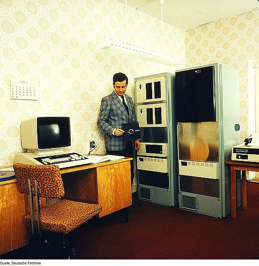 old computer and man holding a floppy disk
